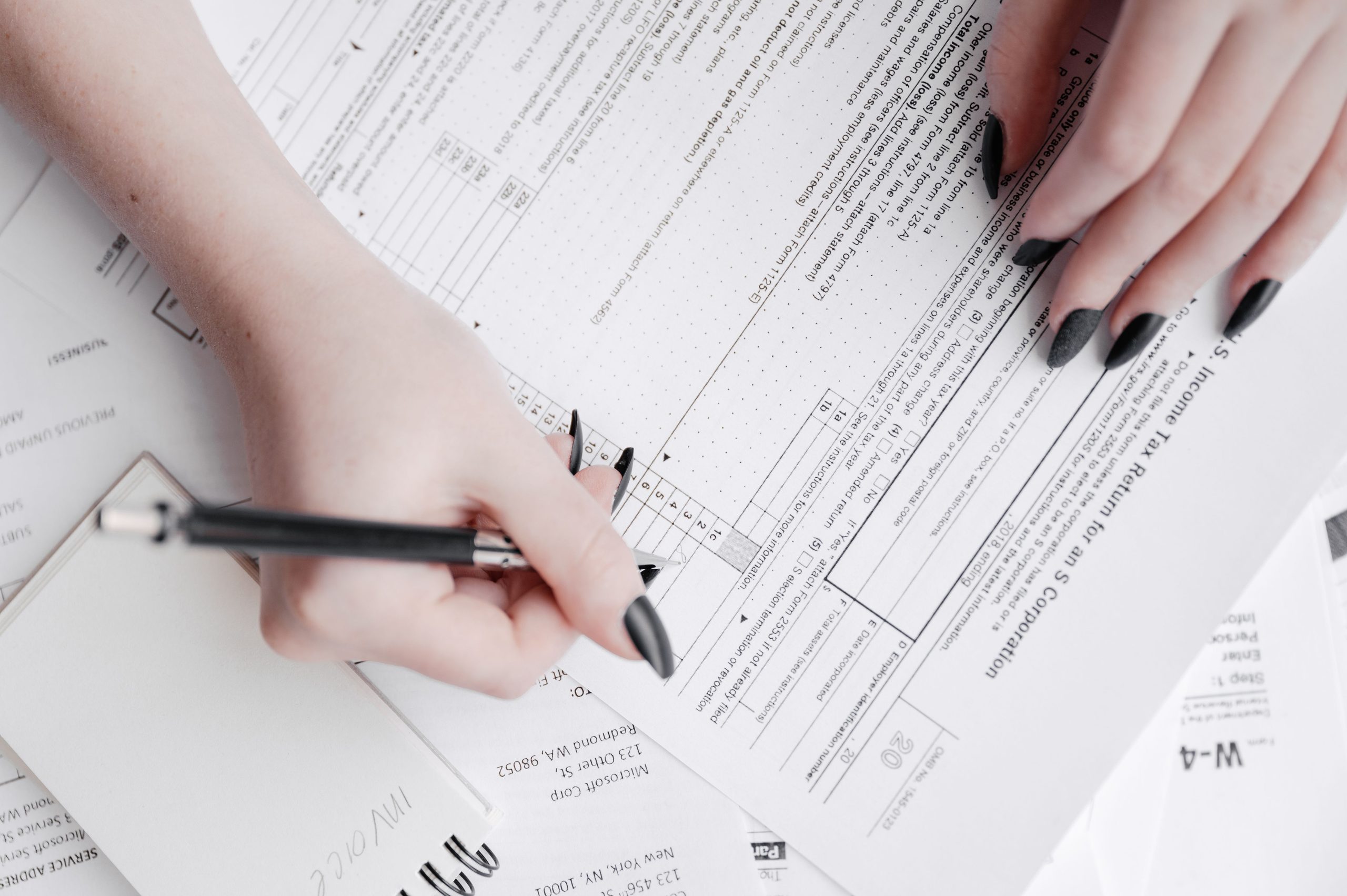 Person filling out tax forms with a pen to work out ADU property tax
